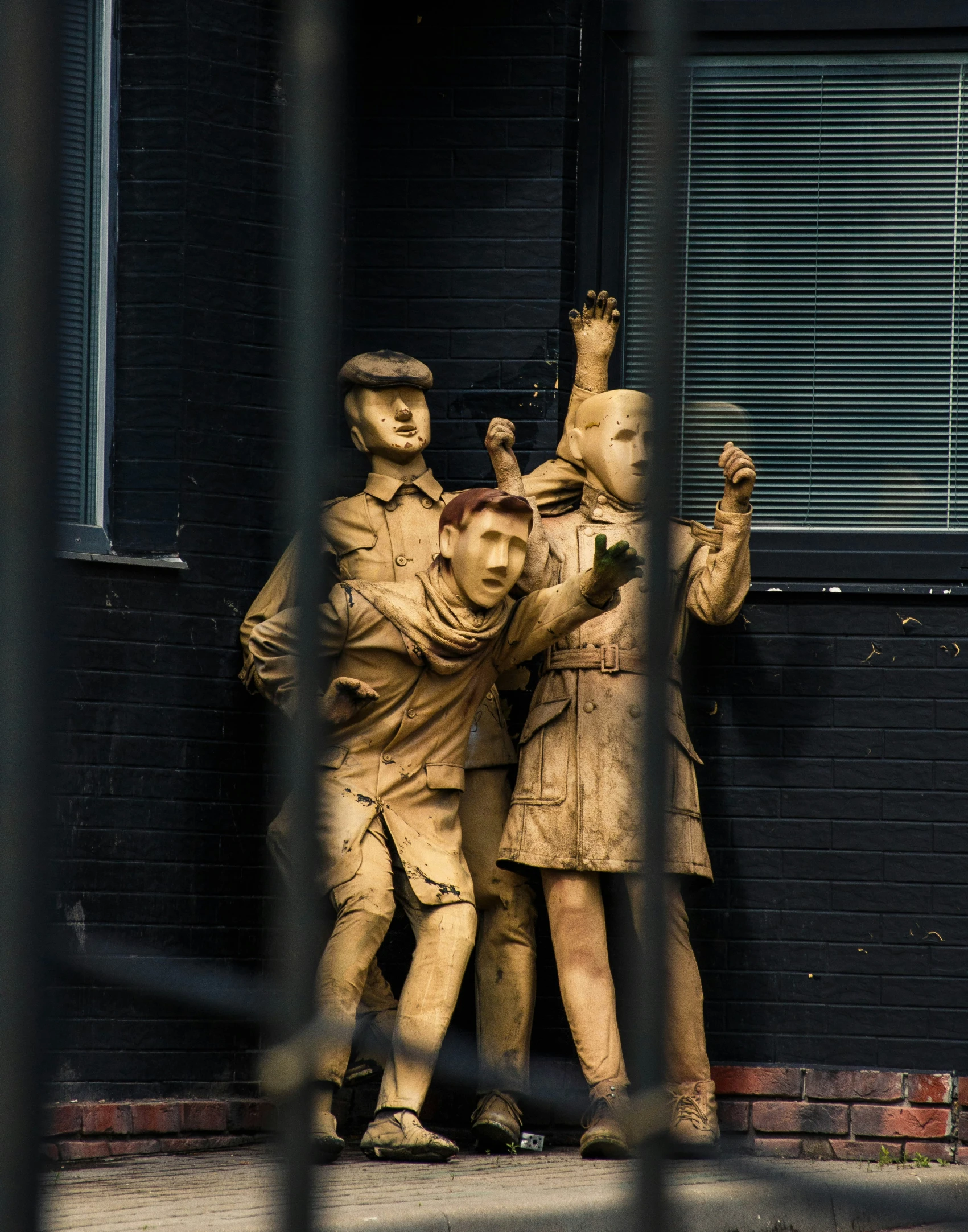 a statue is positioned as if hugging two men