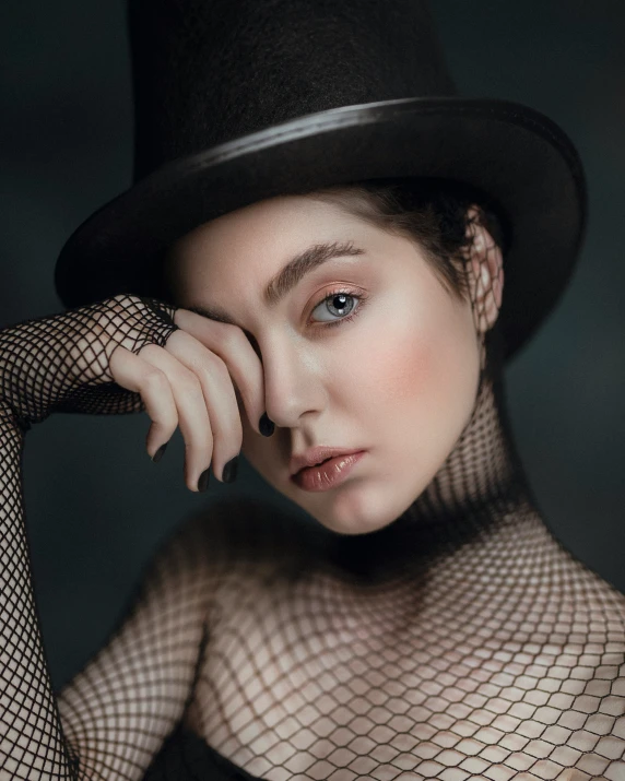 a woman wearing a black hat and mesh top