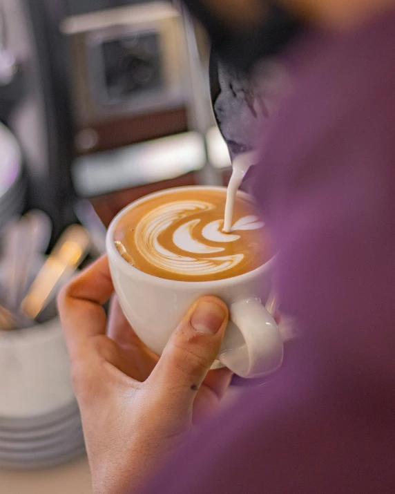 the hand is holding a cup with liquid in it