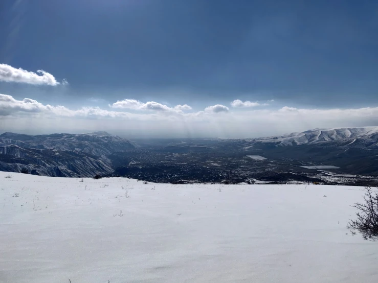 a sun shines brightly from behind a mountain on skis