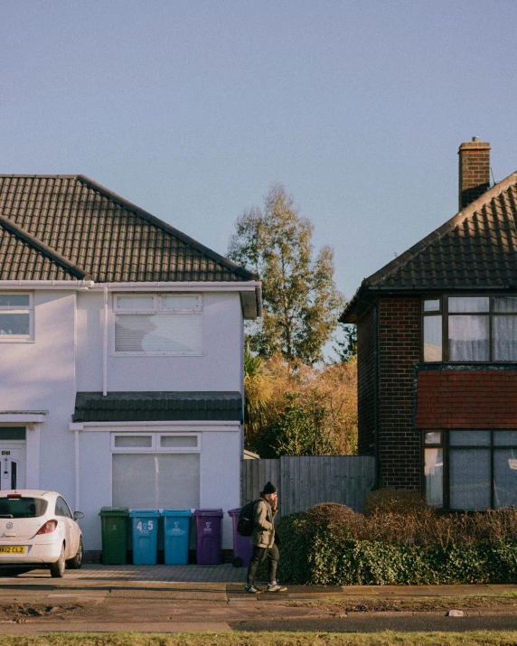 two men in front of white brick house