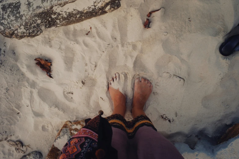 someone's feet on the sand while they are outside