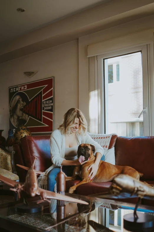 woman sitting on a couch hugging her dog