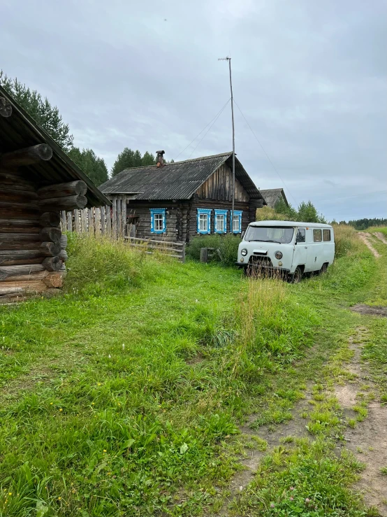 a van parked in front of a building in a grassy field