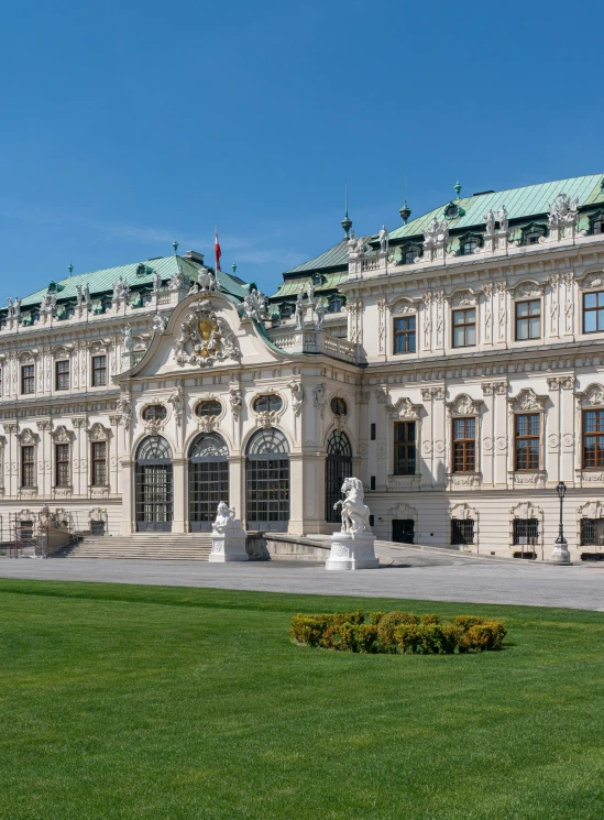 the building has many windows, a lawn, and grass