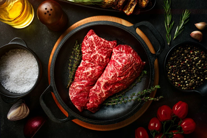 steaks sit in pans next to some onions