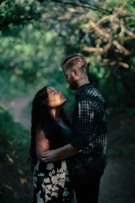 a young couple emcing together in the woods