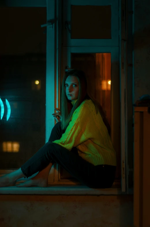 a girl sitting on the window sill smoking a cigarette