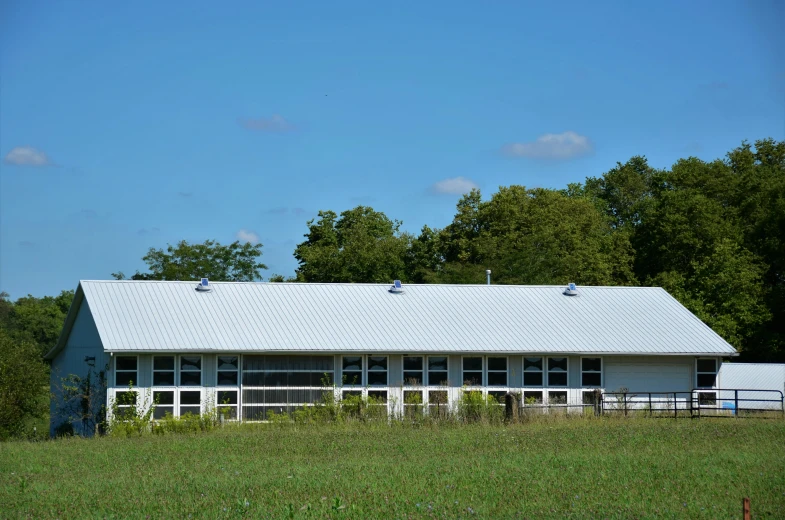 a white building sitting in a field next to trees