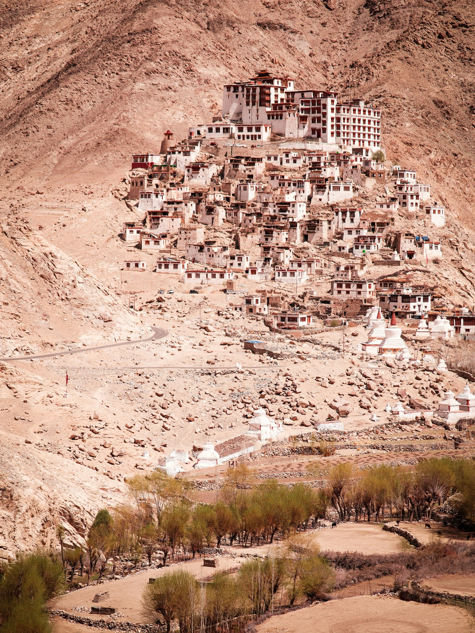 a city in the desert with a hill to the side