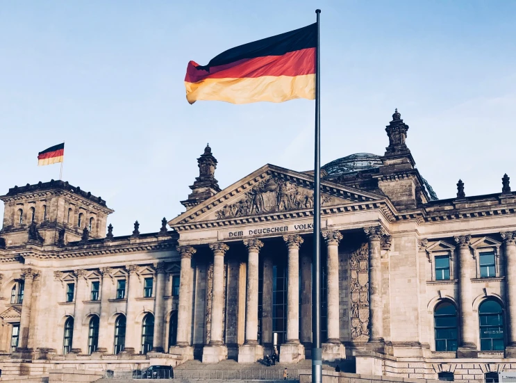 two flags are in front of a building