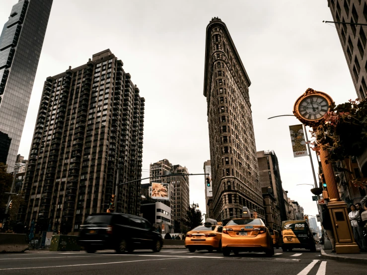 a couple of yellow taxi cabs driving through the middle of a street