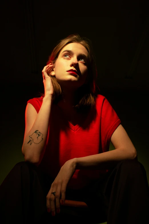 woman posing while holding cigarette with hand and sitting on chair