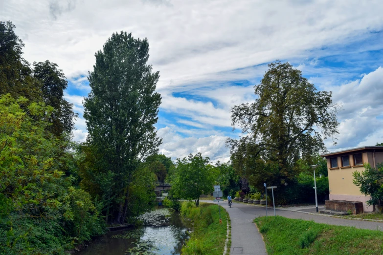 two people are walking down the path next to the water