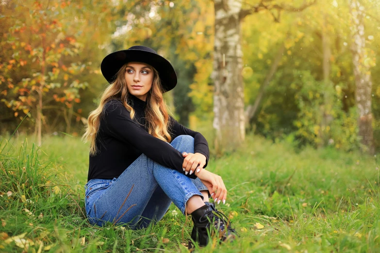 a woman sits on the ground and poses for a picture