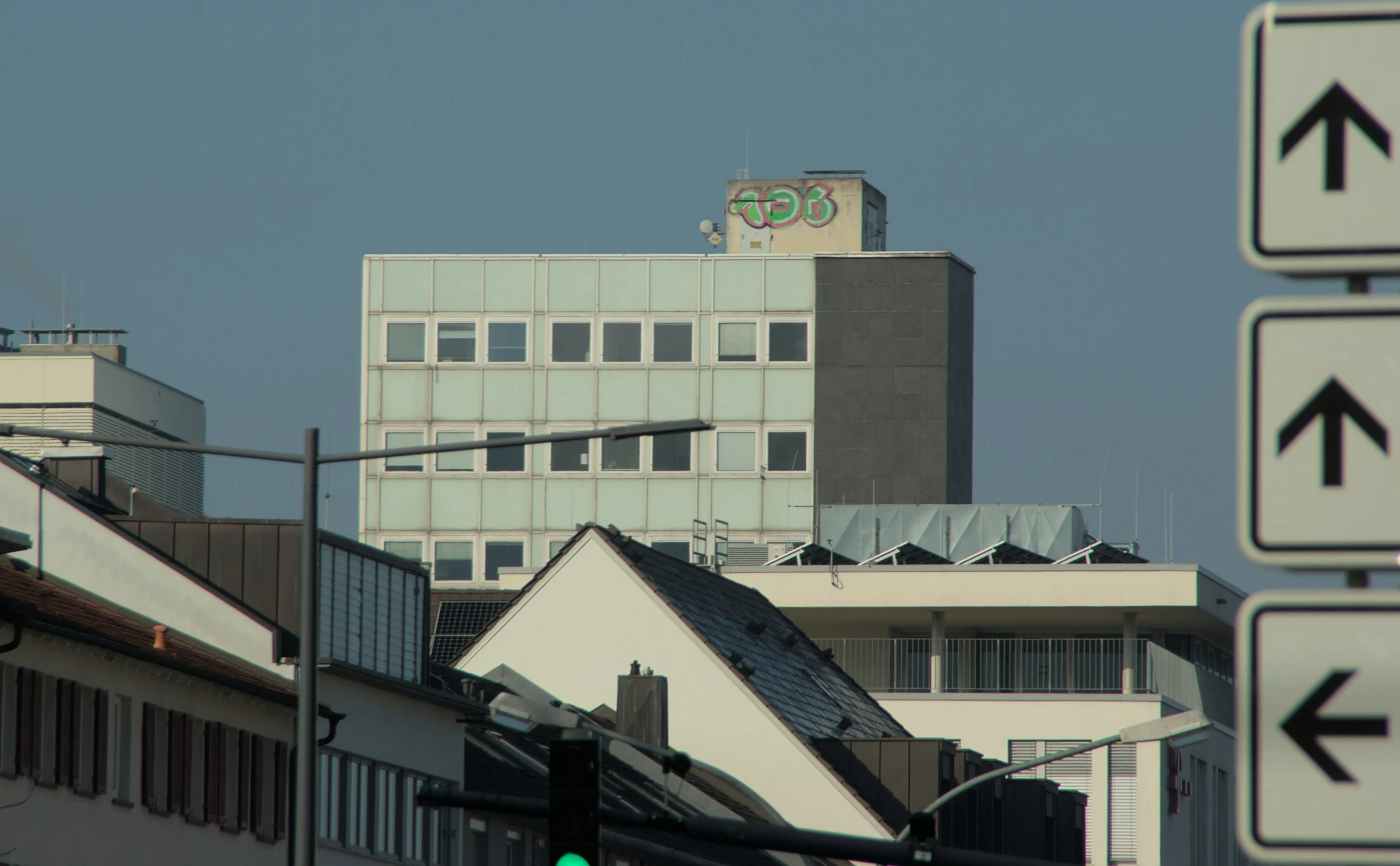 a traffic light with street signs and buildings in the background