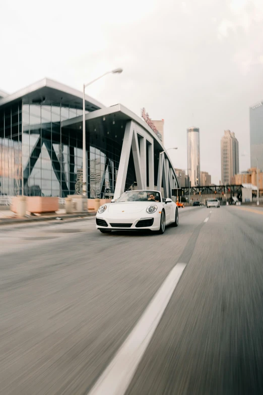 a white sports car driving on the street