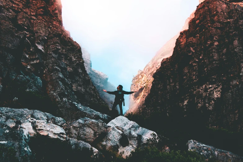 man standing at the end of a rocky mountain trail