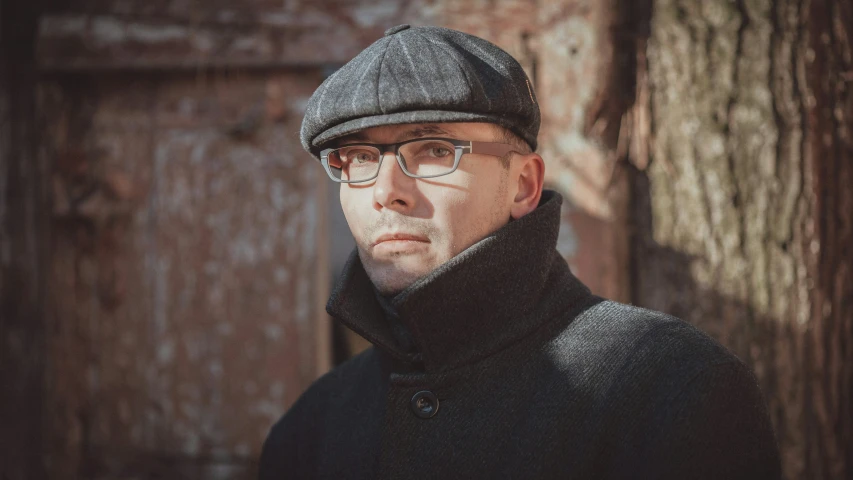 a man in a wool cap with glasses and a jacket