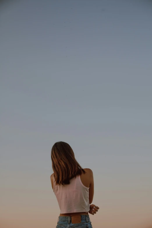 girl flying a kite in the evening with light on