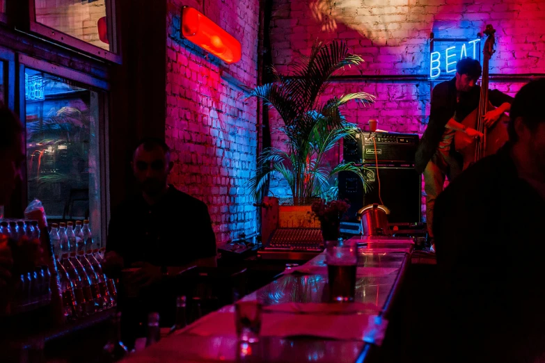 people are sitting at a bar with neon lights