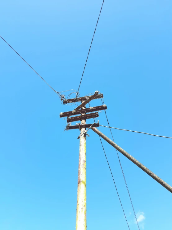 a high view of a telephone pole and some electrical wires