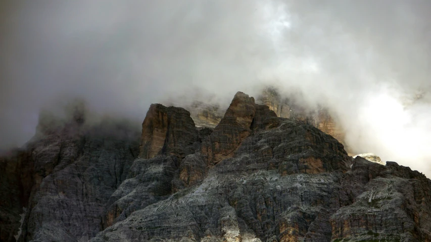 clouds rolling over a mountain and its peaks