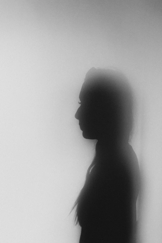 a girl is silhouetted against the wall