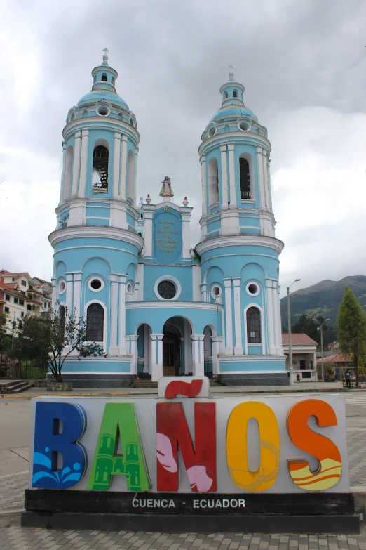 colorful word displayed in front of large building on a cloudy day