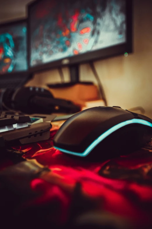 a computer keyboard sitting next to two monitors