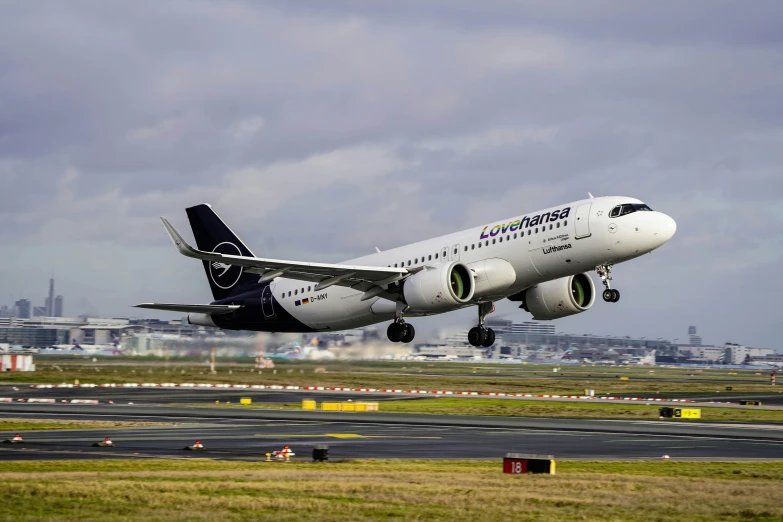 the white airplane is flying low on the runway