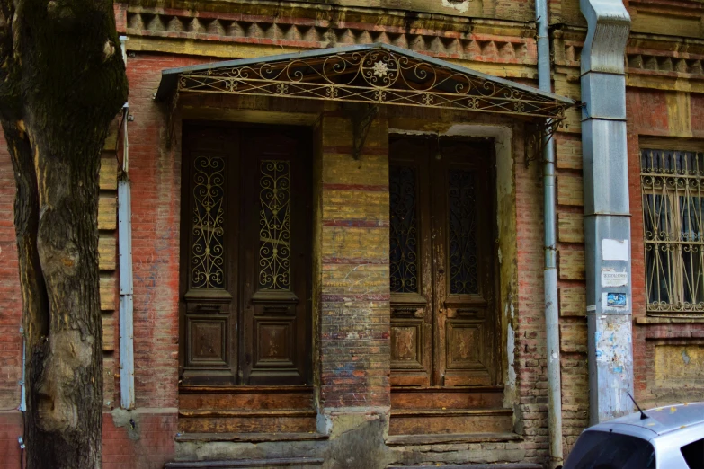 the car is parked outside of a building with brown doors