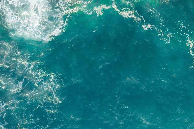 an aerial view of blue sea water with a lot of small waves