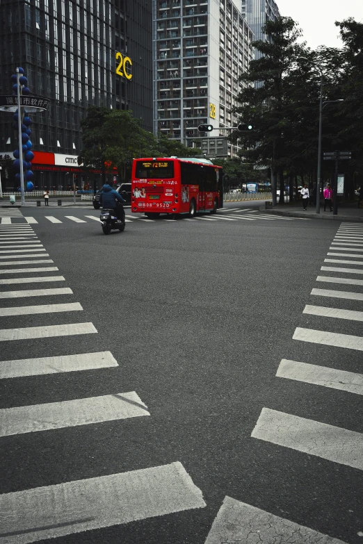 a city street intersection with a bus on the road and cars driving on the street