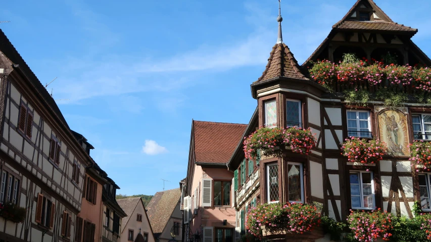 the street is lined with old buildings with flower boxes at the top