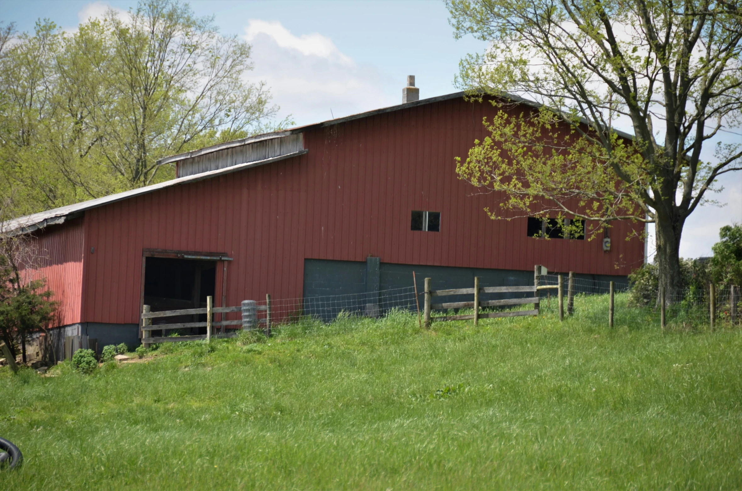 a red barn sitting on top of a lush green field