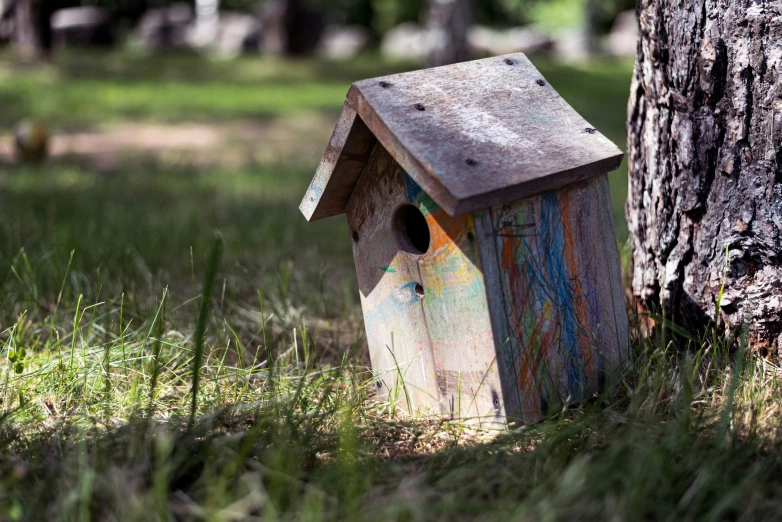 a birdhouse that is painted with various colors