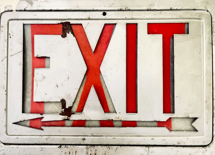 a close up view of a red and white emergency exit sign