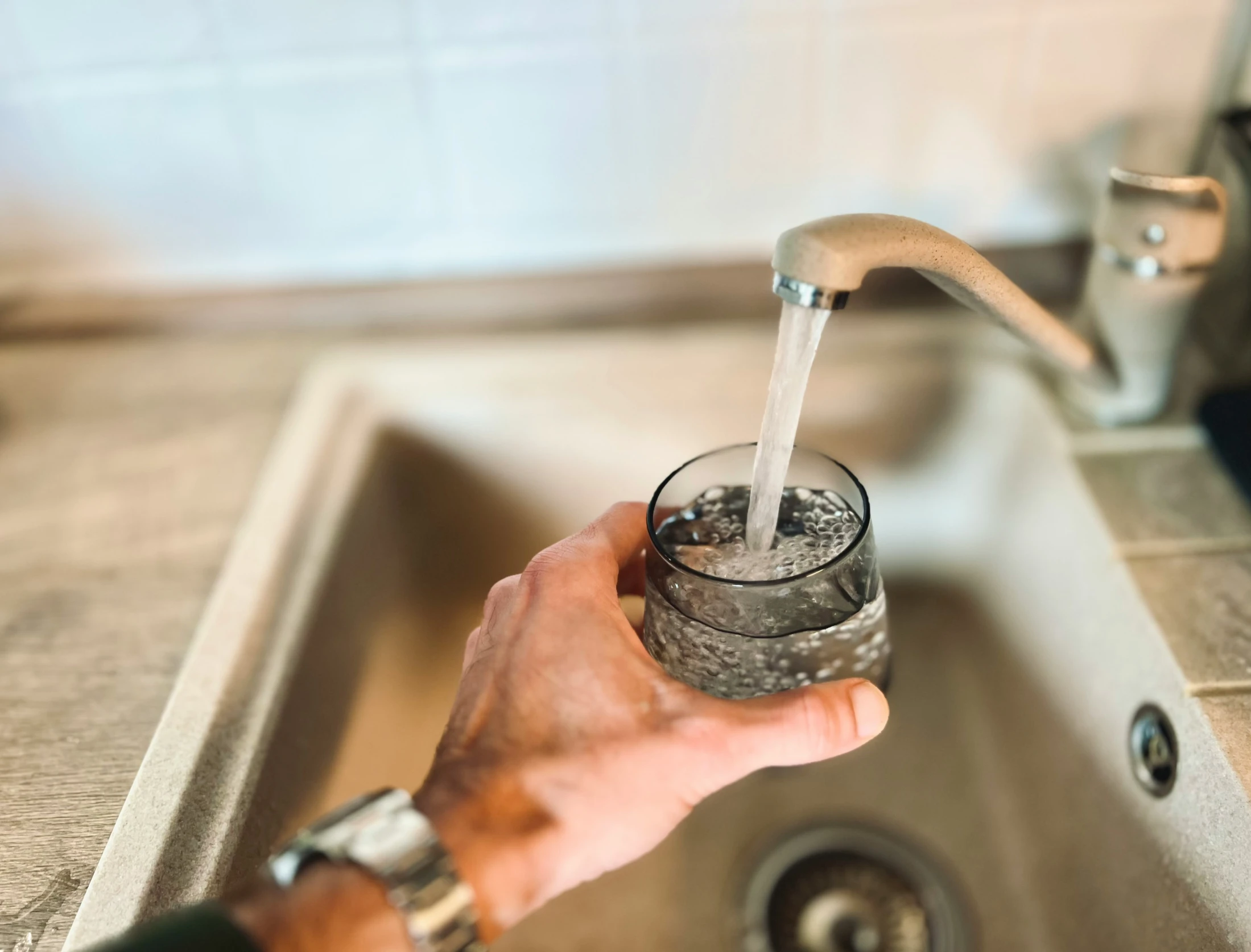 the man is opening the faucet to water a drink