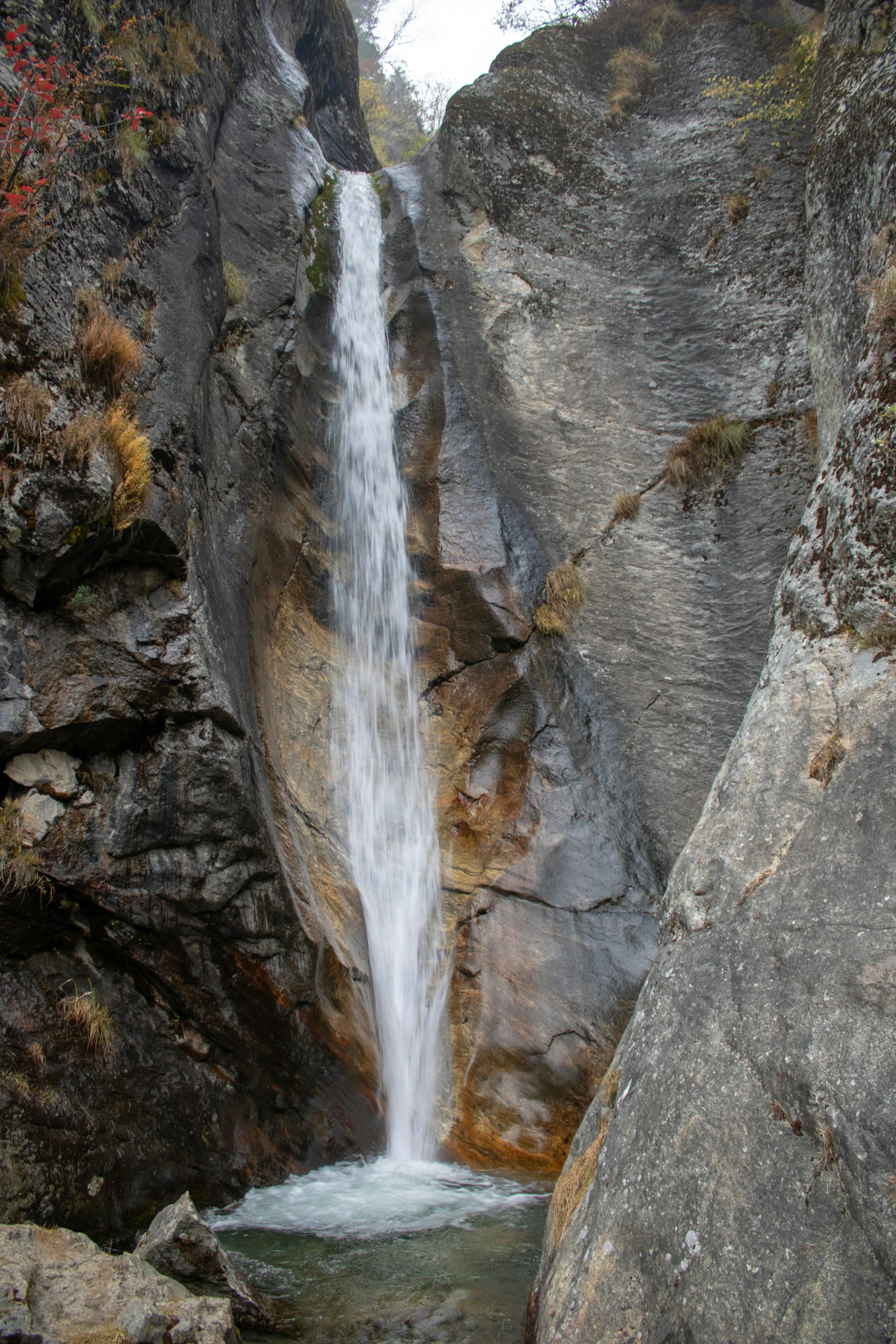 a waterfall flowing through a narrow mountain surrounded by rocks