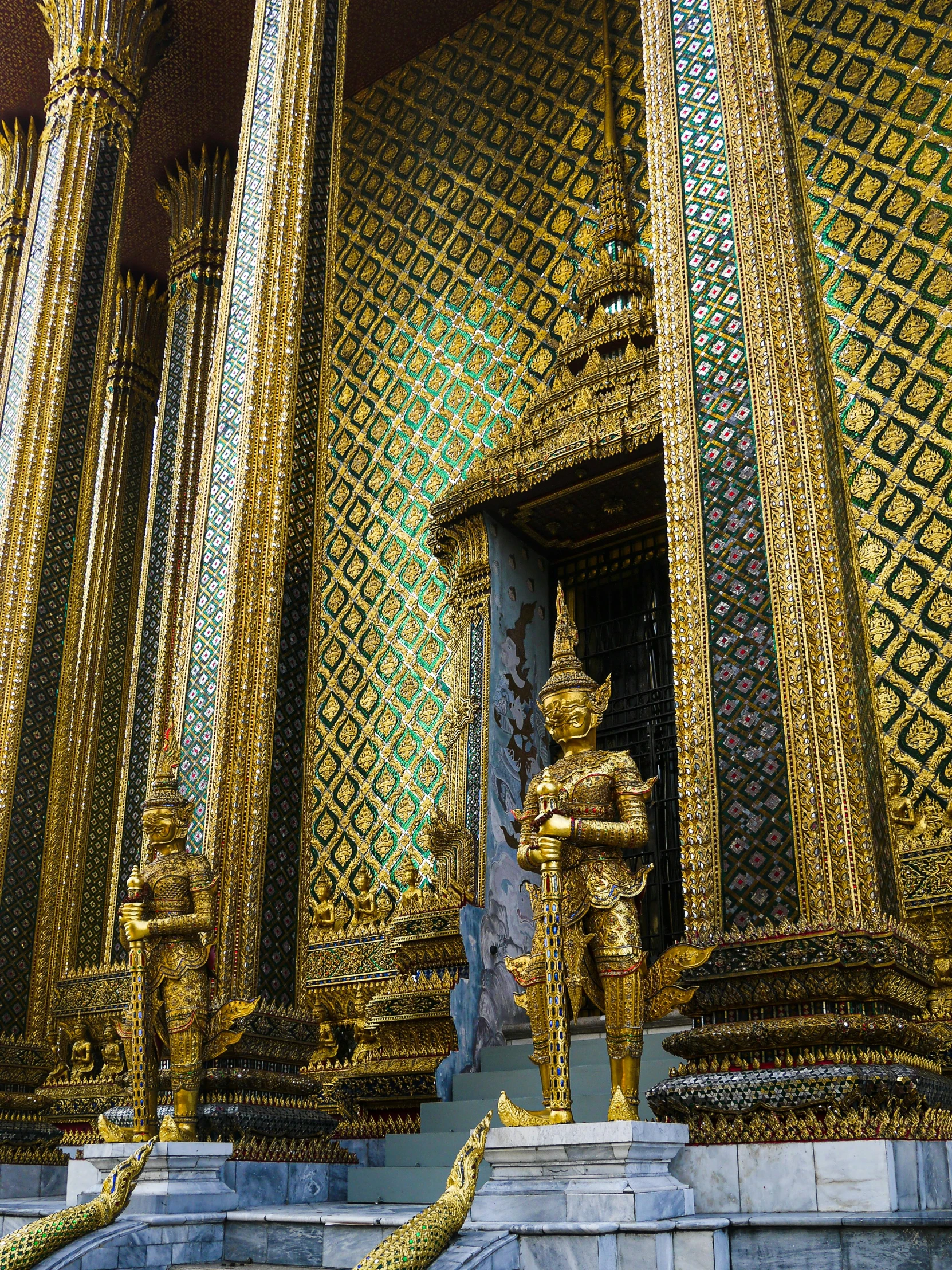 many golden statues are displayed at a palace