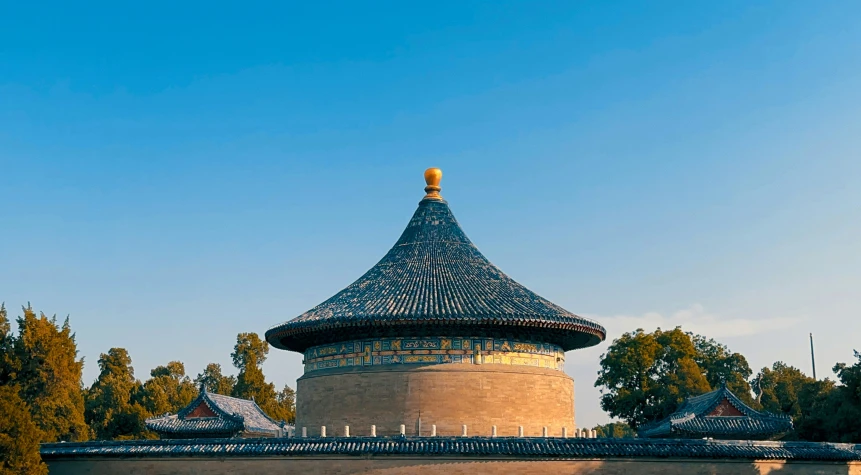 a building with a circular roof next to trees