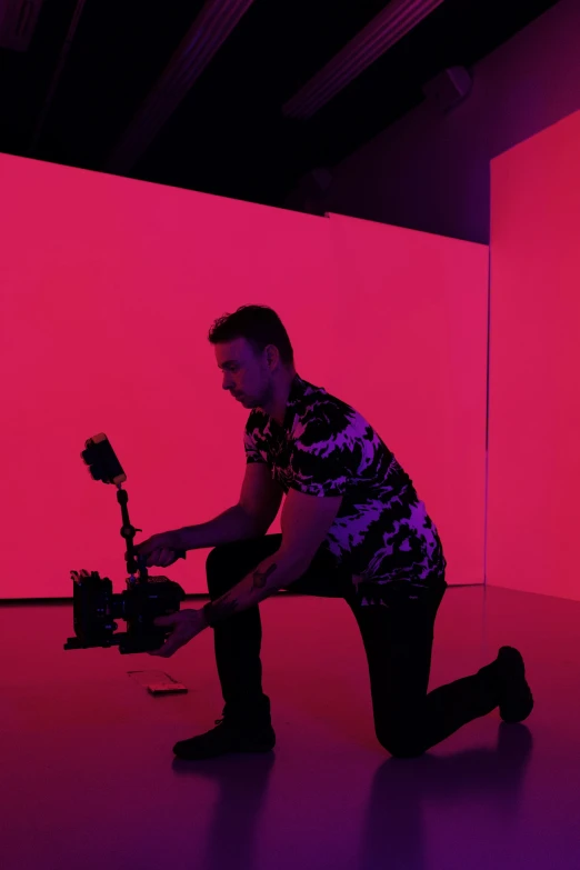 a man kneeling down while working on a camera