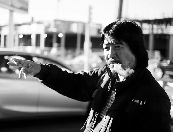 a black and white po of a man smoking and holding out his hand