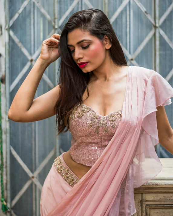 the woman is posing for the camera wearing her pink sari