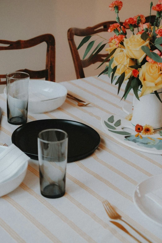 there is a table setting with dishes and vases of flowers