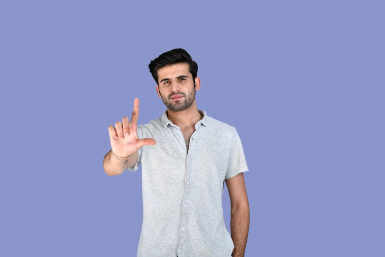 a man making an obscene sign while standing on top of a blue background