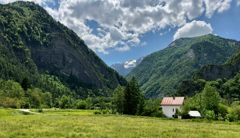 a small house in the middle of a grassy field