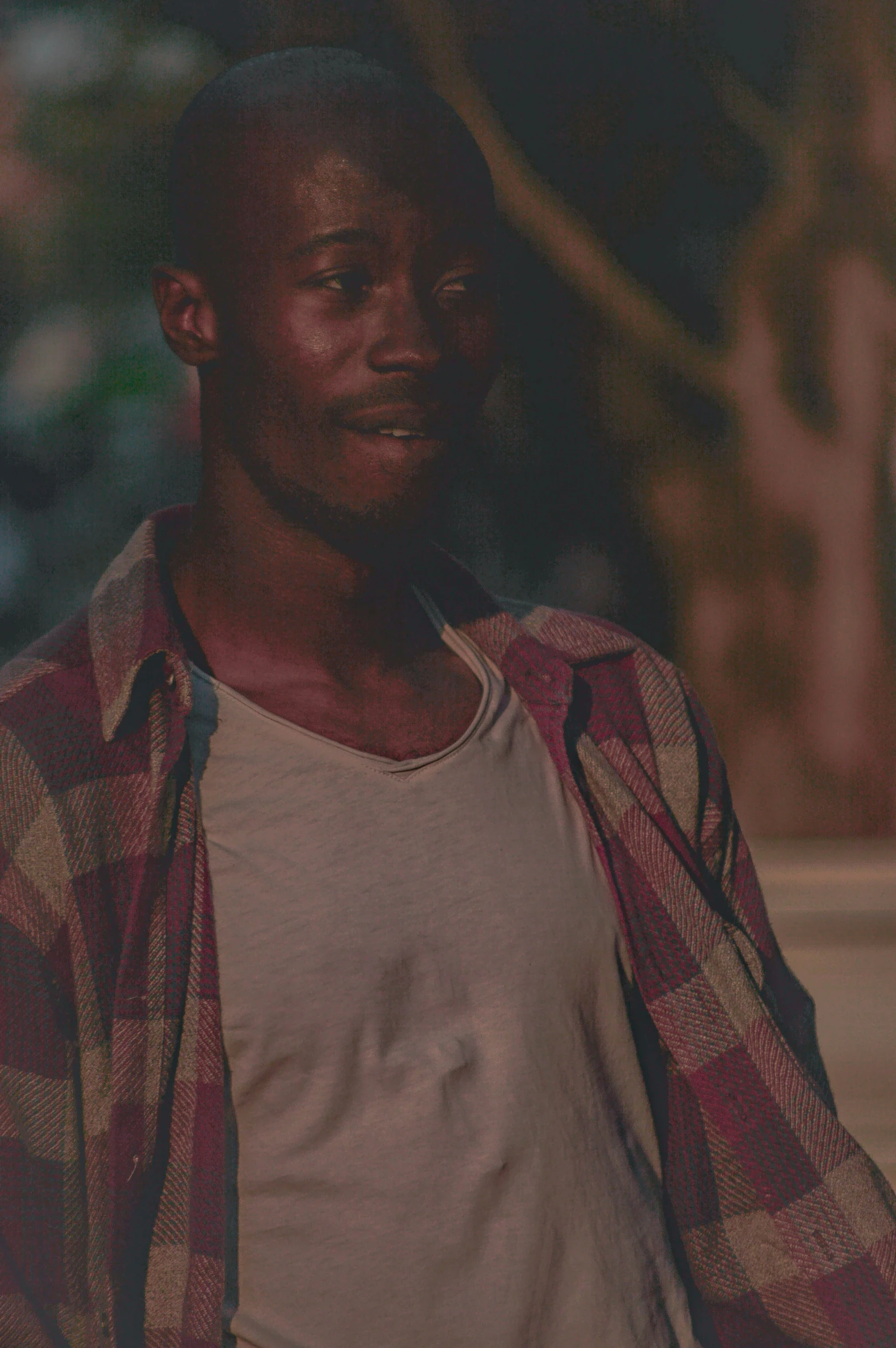 a man in a white shirt smiling with his hands in the pockets