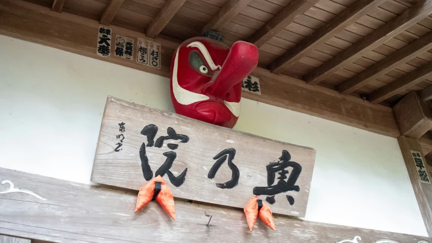 four orange carrots hanging on a sign in front of the window